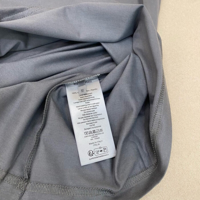 Tessuto sportivo grigio chiaro con etichetta di cura, ideale per attività e comfort quotidiano.