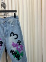 Jeans in denim chiaro con motivi floreali colorati e numero 3, stile vintage e trendy.
