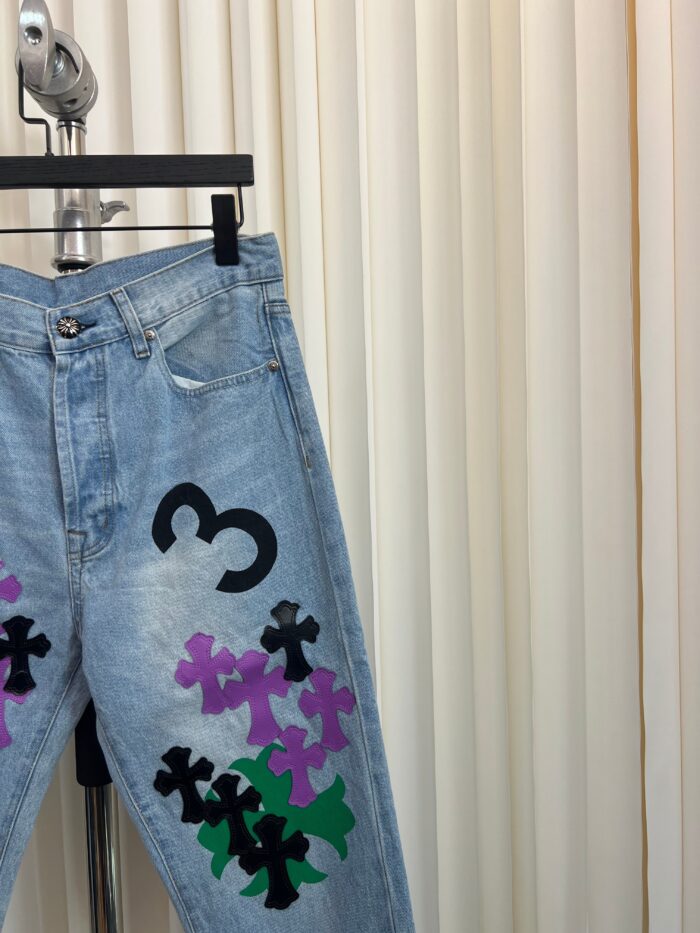 Jeans in denim chiaro con motivi floreali colorati e numero 3, stile vintage e trendy.
