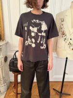 Giovane elegante in t-shirt oversize e pantaloni su misura in ambiente raffinato e moderno.