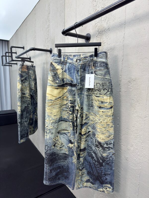 Pantaloni denim oversize con design artistico, effetto sfumato e stile moderno, perfetti per casual.