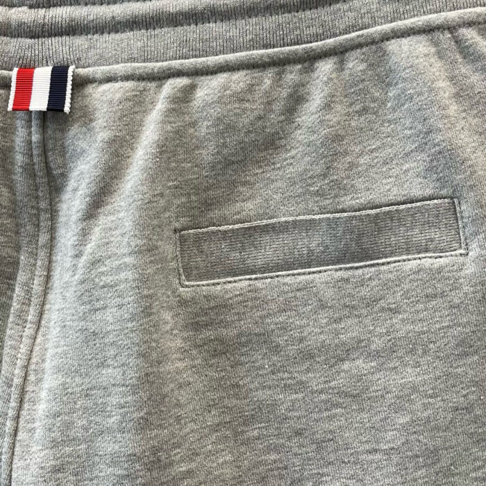 Pantaloni jogger grigi sportivi con fascia colorata e tasca posteriore minimalista.
