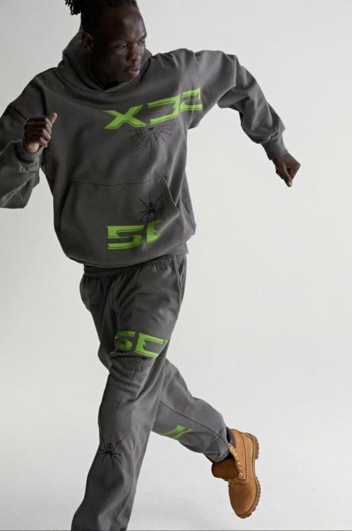 Persona in movimento con outfit athleisure grigio e dettagli neon verdi, stile sporty e moderno.