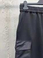 Pantaloni neri sportivi con vita elastica e tasca con bottone, comodi e pratici.