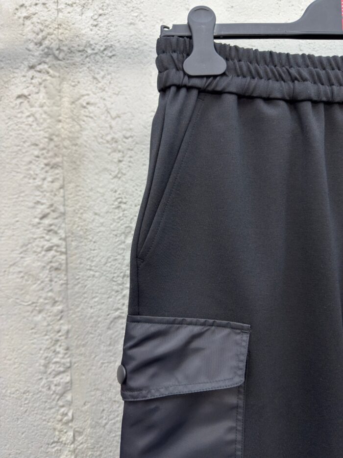 Pantaloni neri sportivi con vita elastica e tasca con bottone, comodi e pratici.
