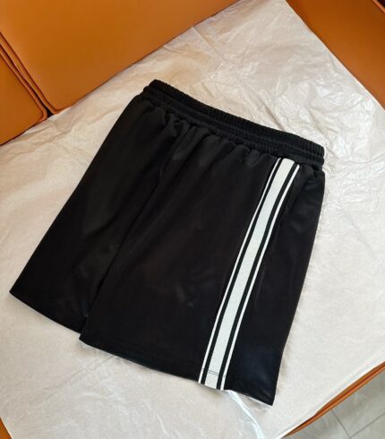 Pantaloncini sportivi neri con banda bianca, elasticizzati, ideali per allenamento e relax.