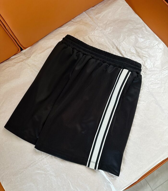 Pantaloncini sportivi neri con banda bianca, elasticizzati, ideali per allenamento e relax.