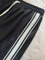 Pantaloncini sportivi neri con Strisce Bianche, elasticizzato e traspirante, ideali per allenamento e sport.