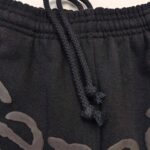 Pantaloni sportivi neri con coulisse, elastico e logo grafico per uno stile casual e comodo.