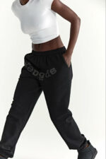 Persona in movimento con outfit sportivo casual: t-shirt bianca e jogger neri comodi e stilosi.