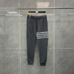 Pantaloni jogger sportivi grigi con strisce contrastate, elastici in vita e polsini stretti.