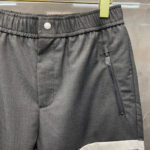 Pantaloni sportivi grigi con elastico, tasca zip e dettagli moderni, ideali per casual e attività.