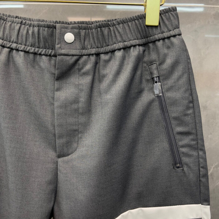 Pantaloni sportivi grigi con elastico, tasca zip e dettagli moderni, ideali per casual e attività.