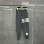 Pantaloni sportivi grigi con strisce bianche, elastico in vita e stile casual moderno.