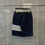 Pantaloncini sportivi navy con strisce bianche, logo e tasca posteriore, stile athleisure.