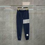 Pantaloni sportivi navy con strisce bianche, elasticizzati, ideali per allenamento e casual.