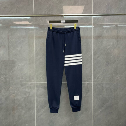 Pantaloni sportivi navy con strisce bianche, elasticizzati, ideali per allenamento e casual.