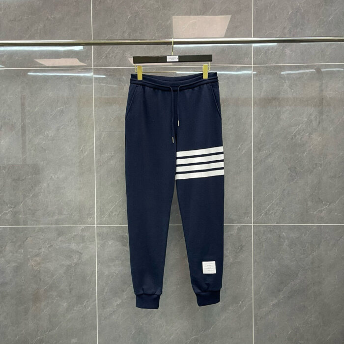 Pantaloni sportivi navy con strisce bianche, elasticizzati, ideali per allenamento e casual.