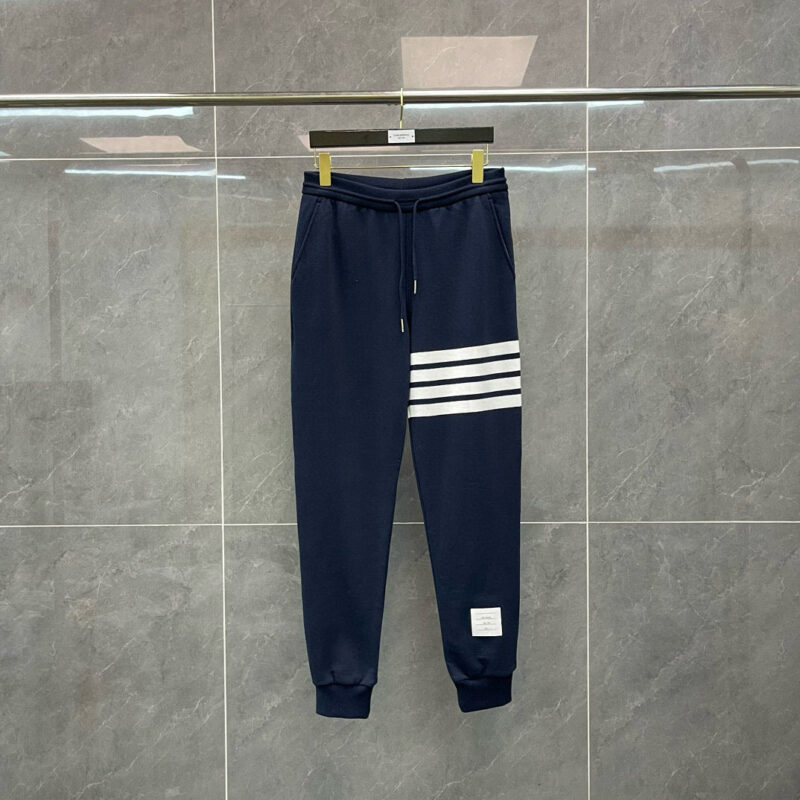Pantaloni sportivi navy con strisce bianche, elasticizzati, ideali per allenamento e casual.