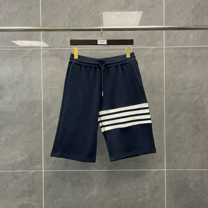 Shorts sportivi navy con strisce bianche, tessuto textured e design moderno, perfetti per casual e sport.