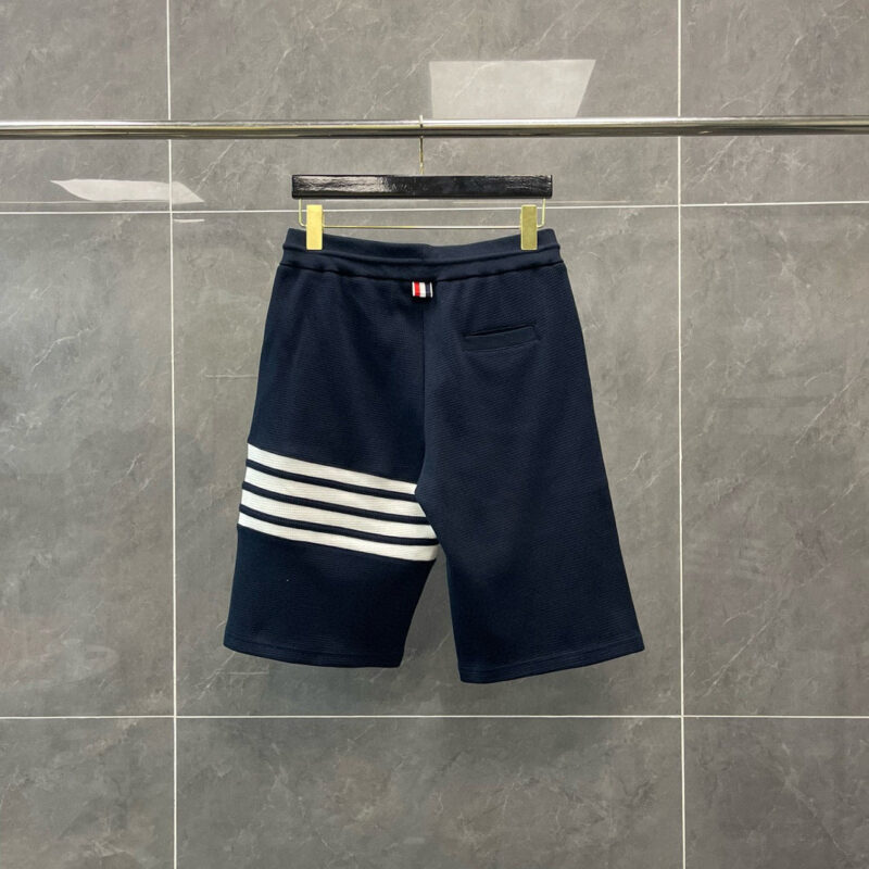 Pantaloncini sportivi navy con tre strisce bianche, look casual e alla moda, dettagli di marca.