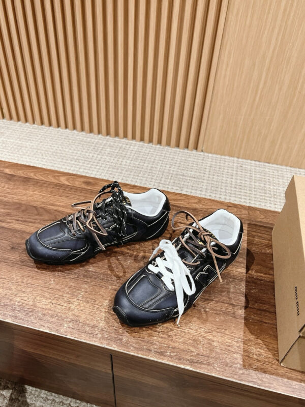 Scarpe da ginnastica nere moderne con lacci mismatched, stile urbano e dettagli di grande design.