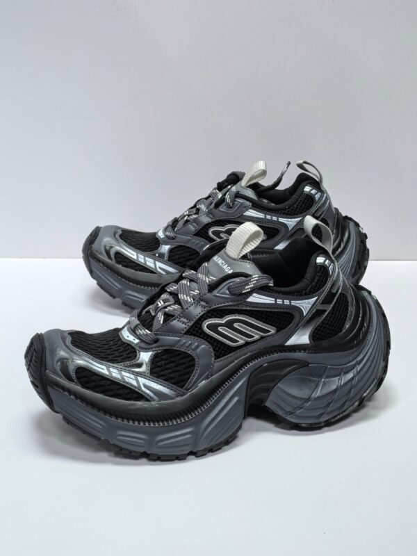 Scarpe sportive nere con dettagli argentati, comfort, grip ottimale e design moderno per ogni attività.