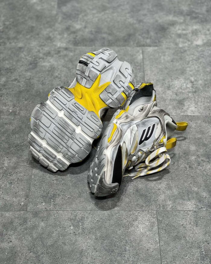 Scarpe sportive gialle e grigie con suola antiscivolo, ideali per corsa e allenamento.