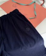 Shorts jogger neri, nastri blu e cartoncino arancione, look casual e confortevole per labbigliamento athleisure.