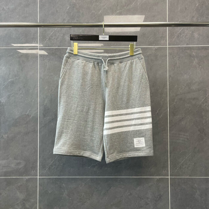 Shorts sportivi grigi traspiranti con banda bianca e cinturino elastico.