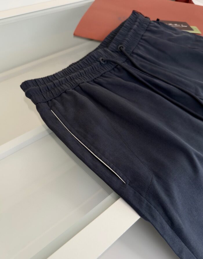 Pantaloncini sportivi neri con vita elastica e tasca riflettente per allenamenti e casual.