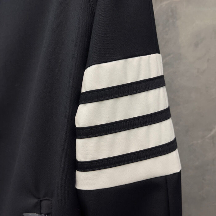 Manica sportiva nera con strisce bianche, stile moderno e adattabile a sporty casual.