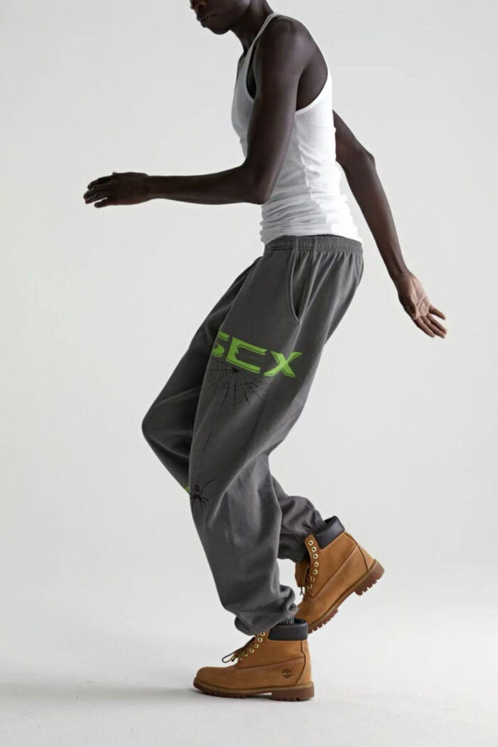Modello in movimento con joggers neon, canotta bianca e stivaletti rugged urban.