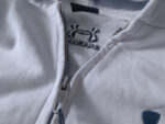 Giacca bianca sportiva con zip e logo crab, morbida e resistente, perfetta per attività casual e sportive.