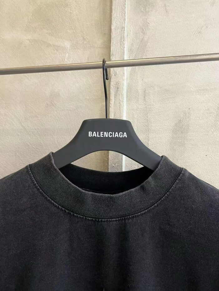 Felpa nera Balenciaga, scollatura relax, stile urbano minimalista con brand su appendiabiti moderno.
