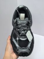 Sneakers Balenciaga futuristiche nere con suola robusta, dettagli riflettenti e design sportivo moderno.