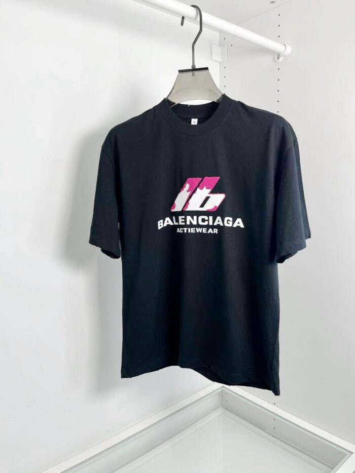 T-shirt Balenciaga nero con logo rosa e bianco, stile urban streetwear, moda moderna casual.