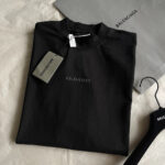 Maglietta nera Balenciaga minimalista in cotone con logo elegante e accessori coordinati.