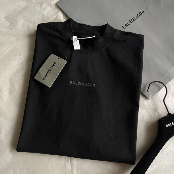 Maglietta nera Balenciaga minimalista in cotone con logo elegante e accessori coordinati.