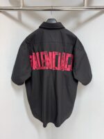 Camicia nera Balenciaga con logo rosa oversize sul retro, moda streetwear di lusso.