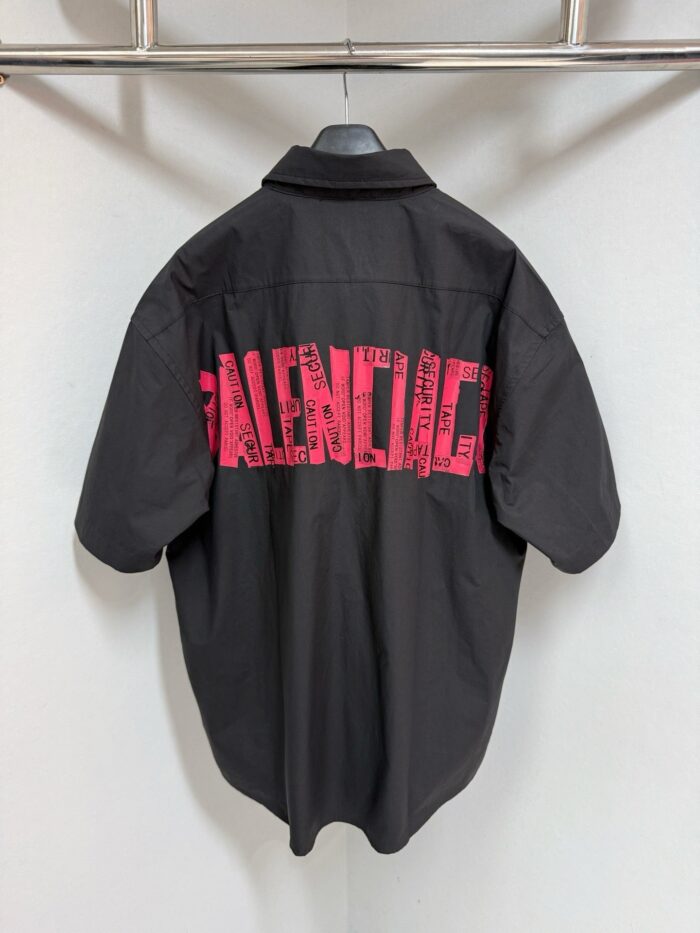 Camicia nera Balenciaga con logo rosa oversize sul retro, moda streetwear di lusso.