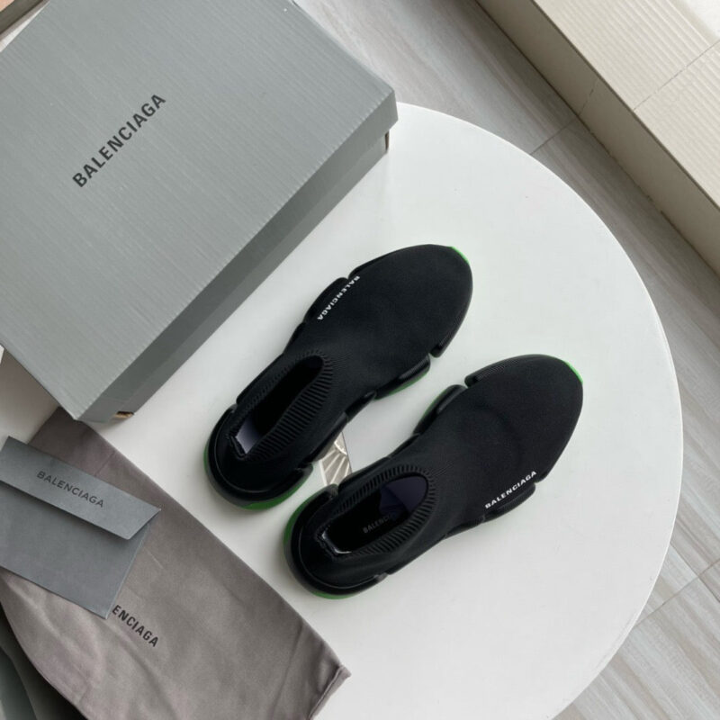 Sneakers Balenciaga nere innovative, con packaging elegante e dettagli raffinati, in ambiente moderno.
