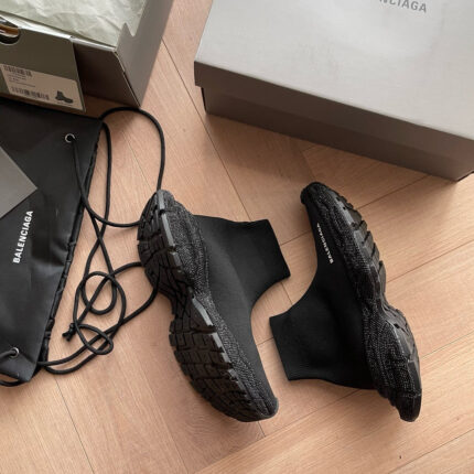 Sneakers nere Balenciaga con packaging di lusso su pavimento in legno elegante.