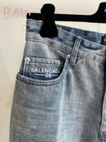 Jeans Balenciaga in denim di alta qualità con logo ricamato e tag sulla tasca posteriore.