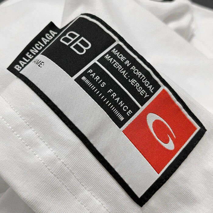 Etichetta Balenciaga Jersey, Made in Portugal, con logo rosso e dettagli di marca.