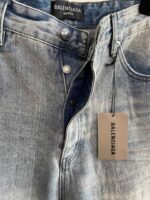 Jeans Balenciaga in denim leggero con dettagli vintage e logo sulla targhetta.