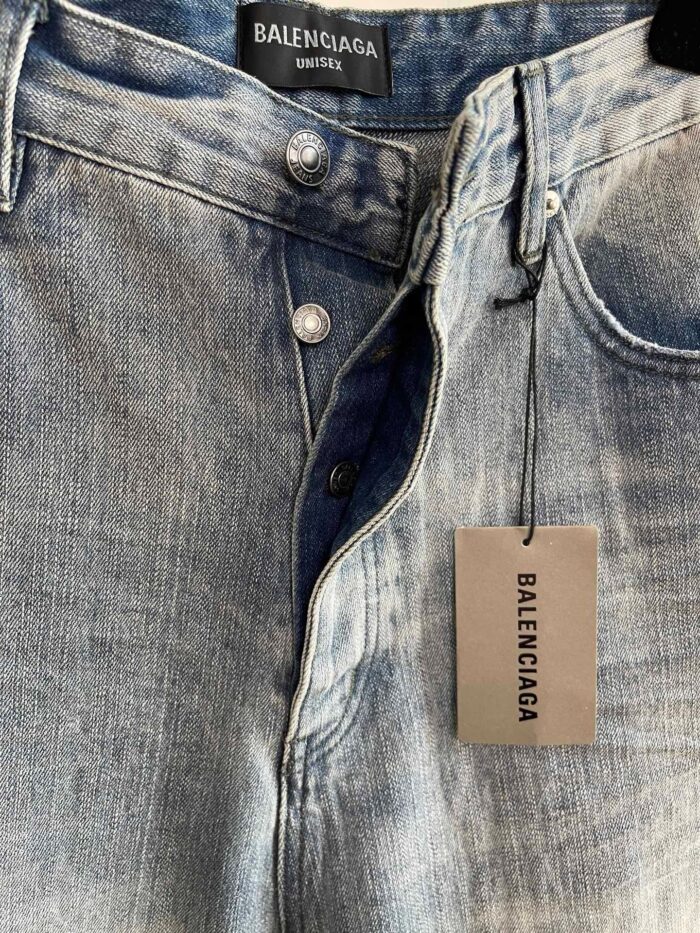 Jeans Balenciaga in denim leggero con dettagli vintage e logo sulla targhetta.