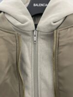 Giacca Balenciaga ibrida con cappuccio, stile moderno e materiali contrastanti.