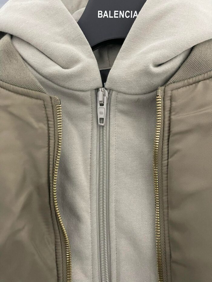 Giacca Balenciaga ibrida con cappuccio, stile moderno e materiali contrastanti.