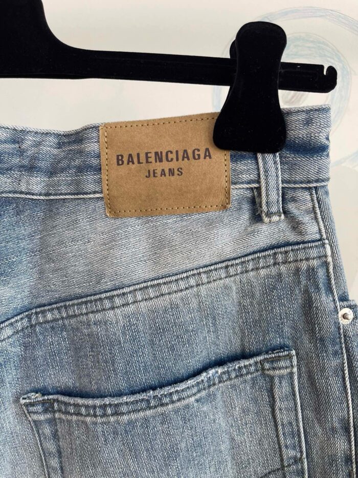 Jeans Balenciaga in denim chiaro con cuciture detailing e patch in pelle, stile casual di lusso.